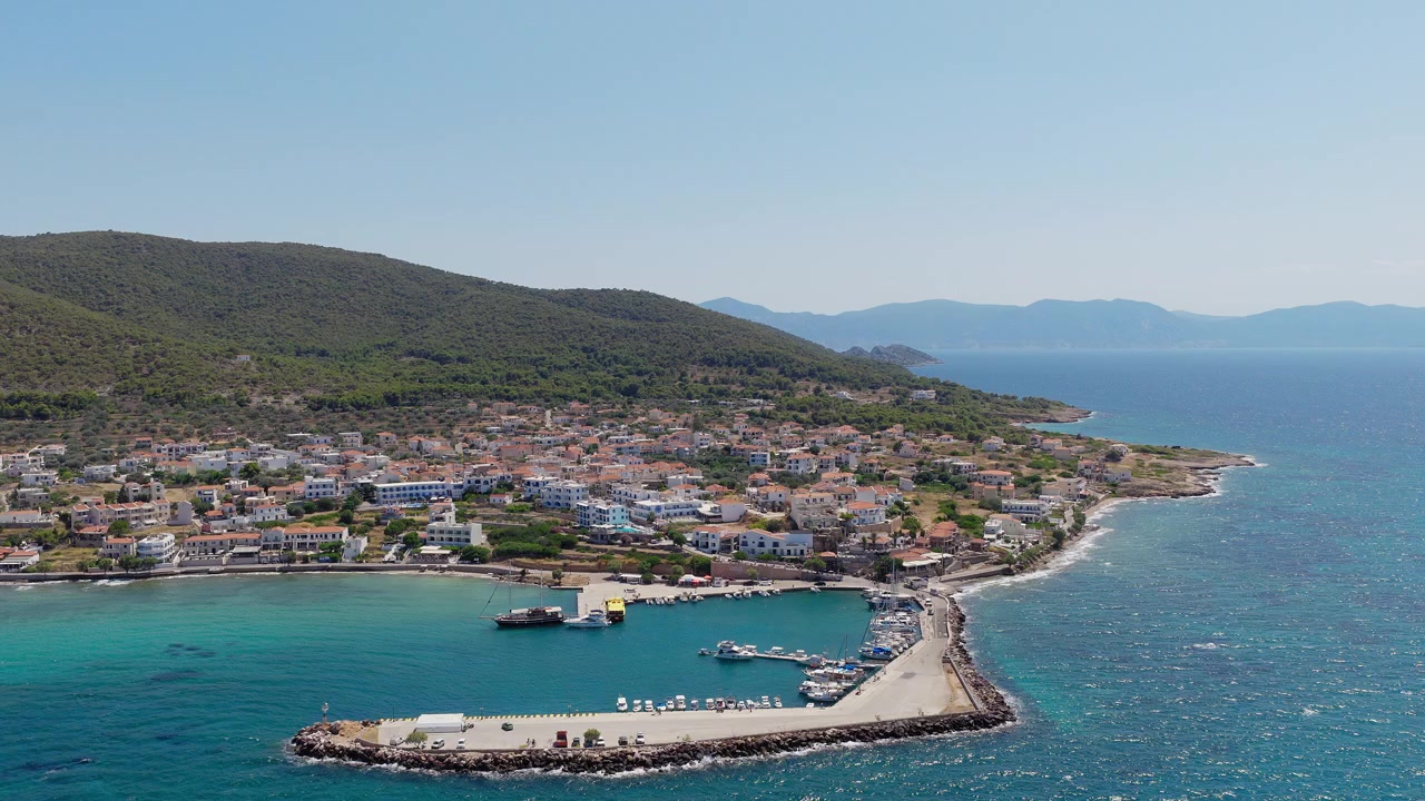 Yunanistan, Agistri Adası'ndaki Megalochori köyü ve limanının panoramik drone çekimi. Açık bir yaz günü. Çam ağaçlarıyla kaplı yamaç, küçük liman.
