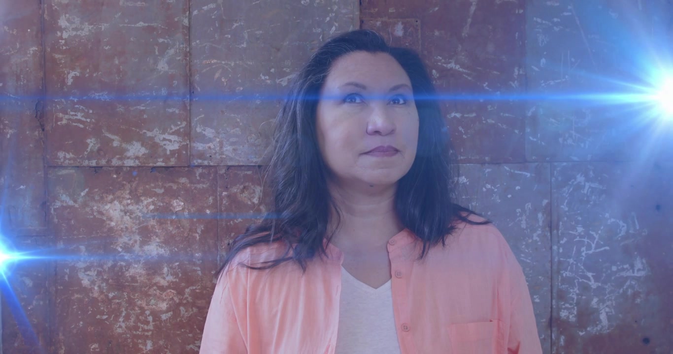 Woman standing against backdrop with beam sweeping across face and tracking light during tech demo