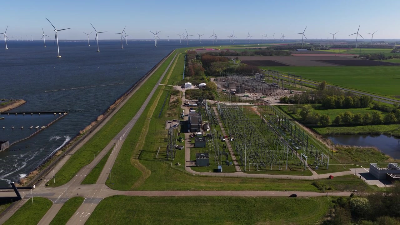 Aerial drone view of a high voltage substation with transformers and electricity grid infrastructure for power distribution.