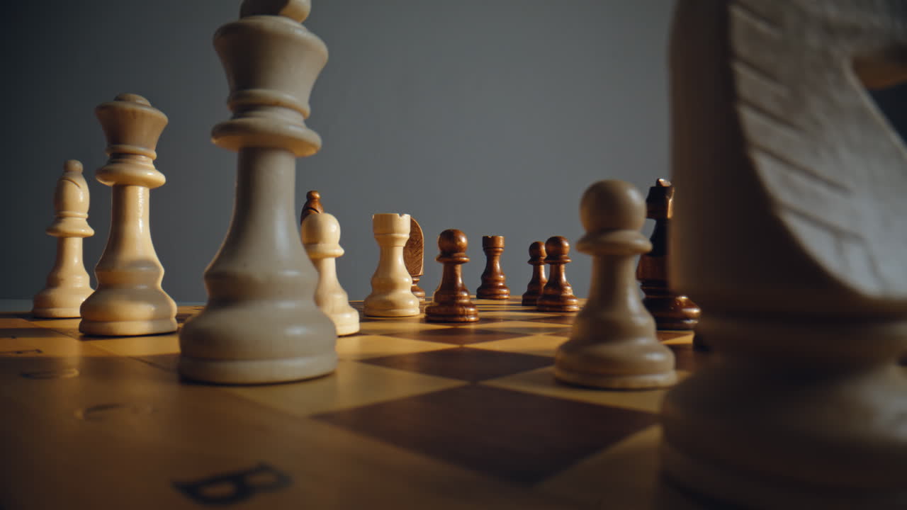 Arm placing chess unit into contested match board zone near darker foes closeup