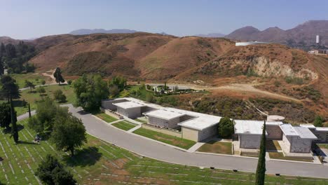 wide descending aerial shot of a large stone mausoleum at a california mortuary