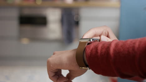 Close-up-of-woman-using-smart-watch-at-home