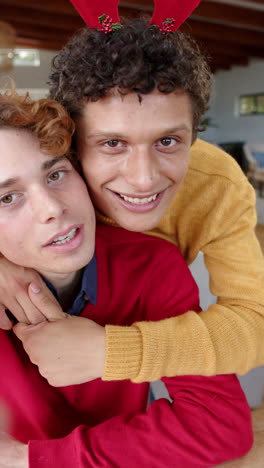 vertical video of diverse gay male couple having video call at home, slow motion