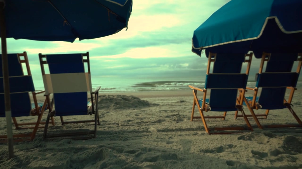 Lettini e ombrelloni da spiaggia sulla spiaggia di fronte all'oceano