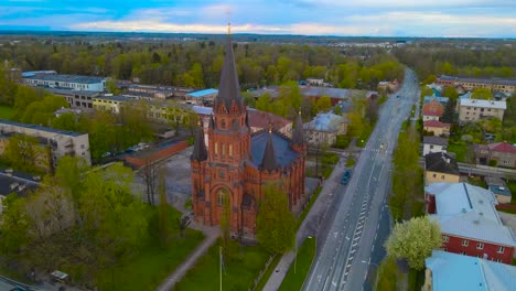 gorgeous aerial drone footage of peetri large and majestic lutheran holy religious church in tartu estonia during morning or evening day light time with horizon in the background of the small city.