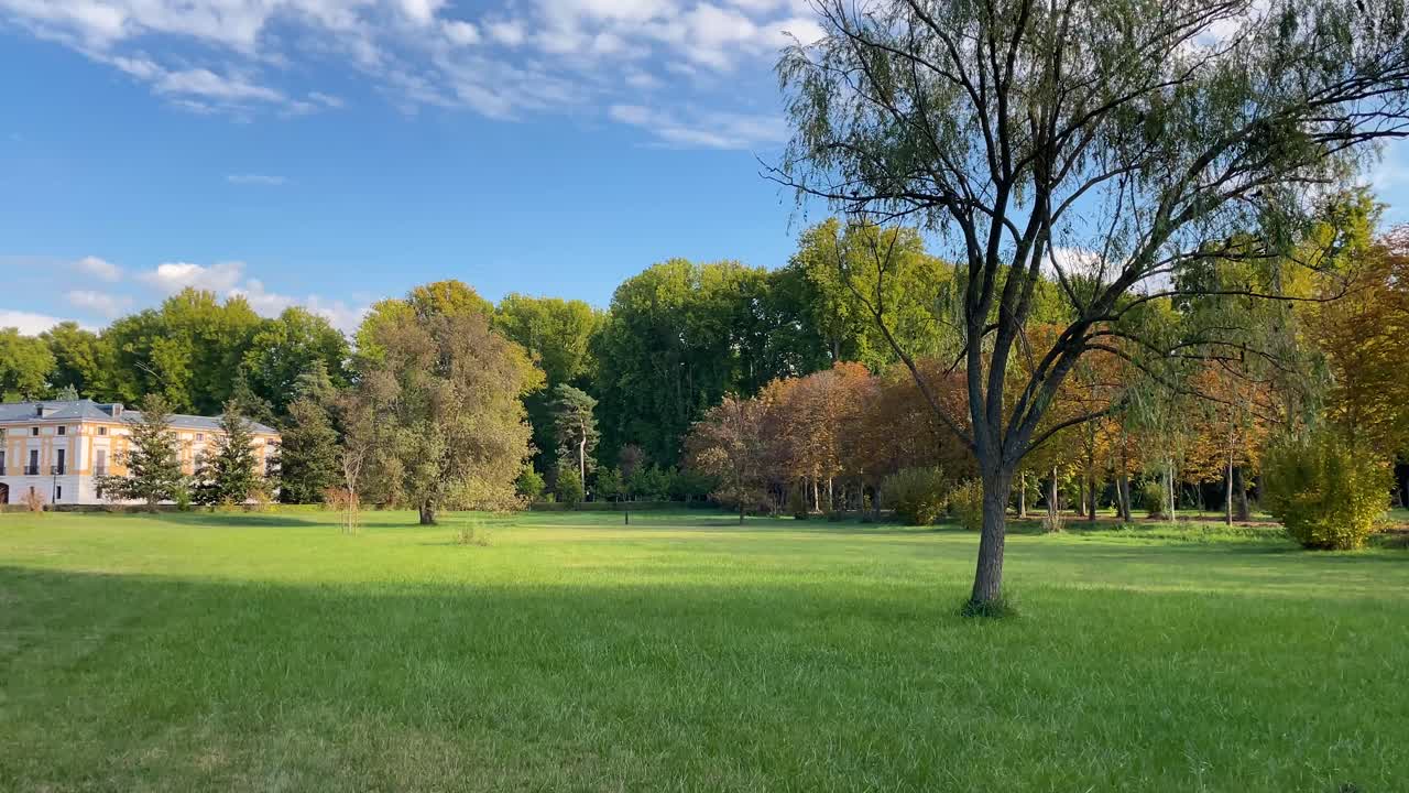 Panoramic filming in the beautiful surroundings of the Casa del Labrador in the Prince's gardens, we see a green field, a large grove of trees and the country residence of the former kings.