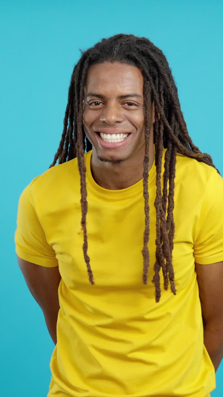 Man with dreadlocks in a yellow shirt