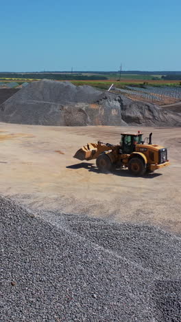 bulldozer at construction site. aerial view of heavy earthmover working at construction site vertical video