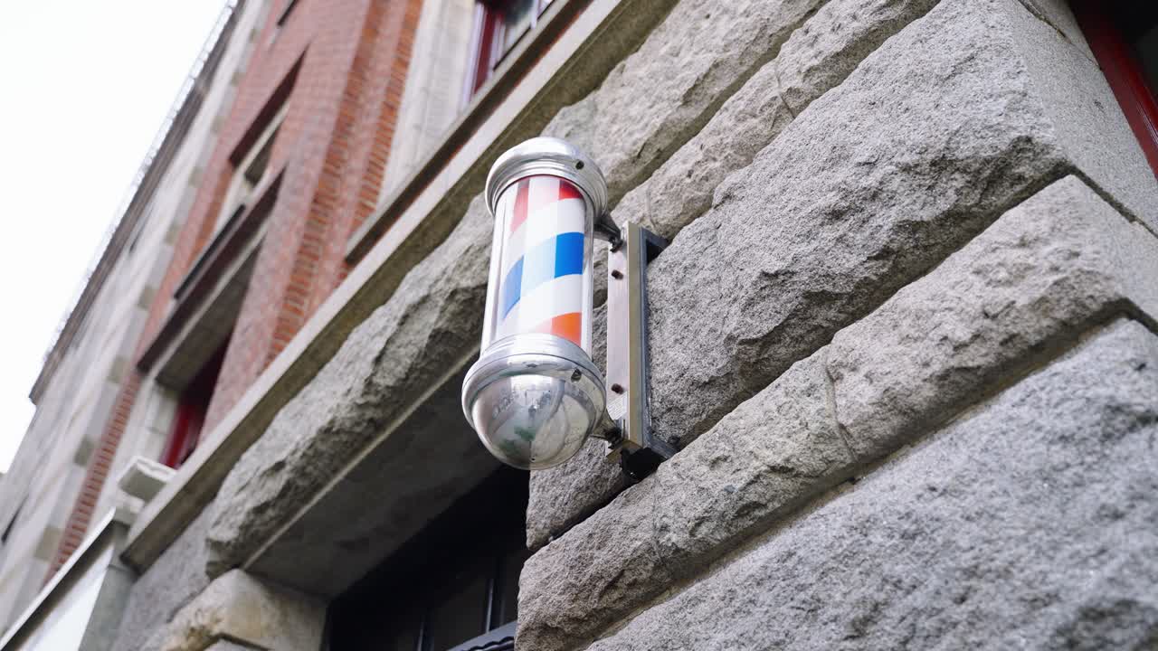 luz de poste de barbero giratorio en el exterior de una barbería en ámsterdam, países bajos