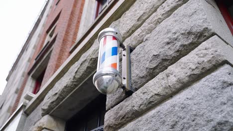 luz de poste de barbero giratorio en el exterior de una barbería en ámsterdam, países bajos