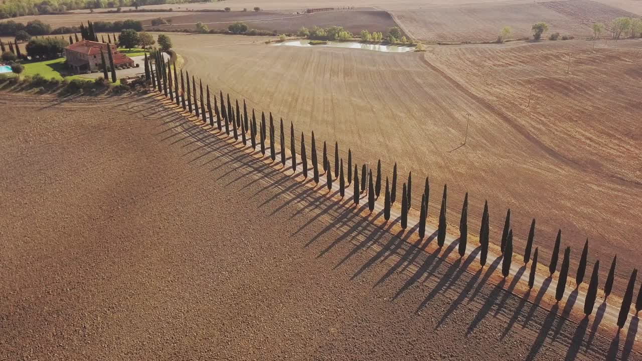 dron de rotación lenta sobre villa toscana con cipreses típicos en el camino de entrada en 4k