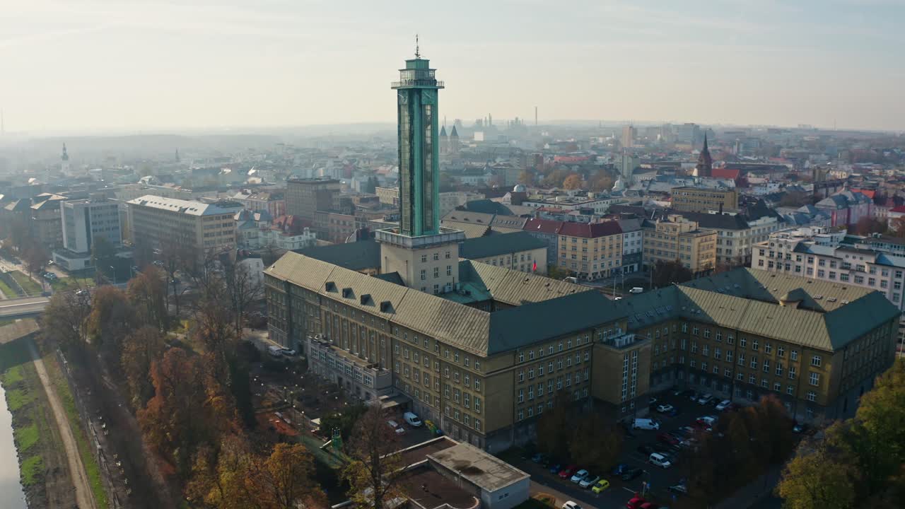 Down drone shot around ostrava city hall tower in summer