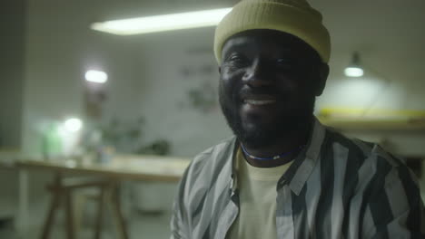 smiling black man wearing a yellow beanie