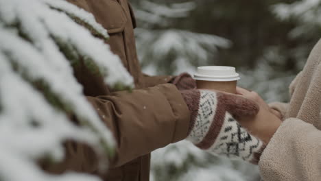 couple enjoying coffee in a snowy forest