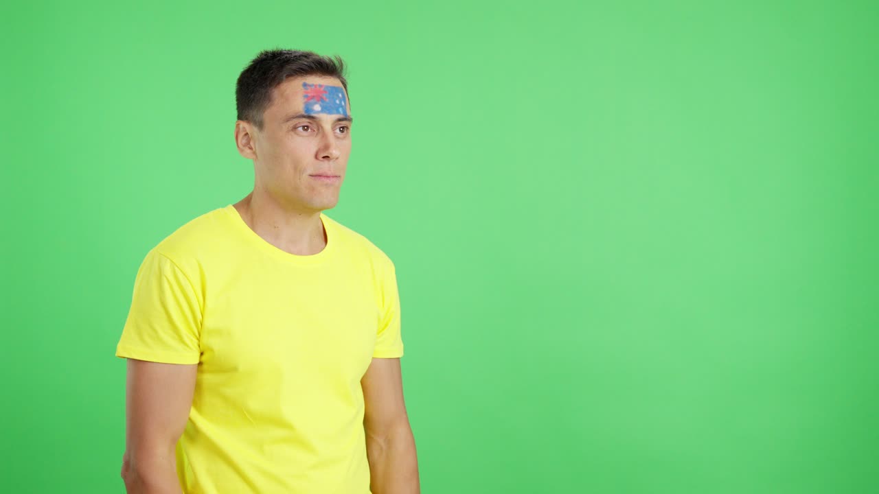 Happy man with australian flag painted on face looking away