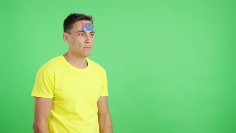 Happy man with australian flag painted on face looking away