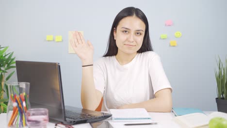 Female-student-waving-to-the-camera.