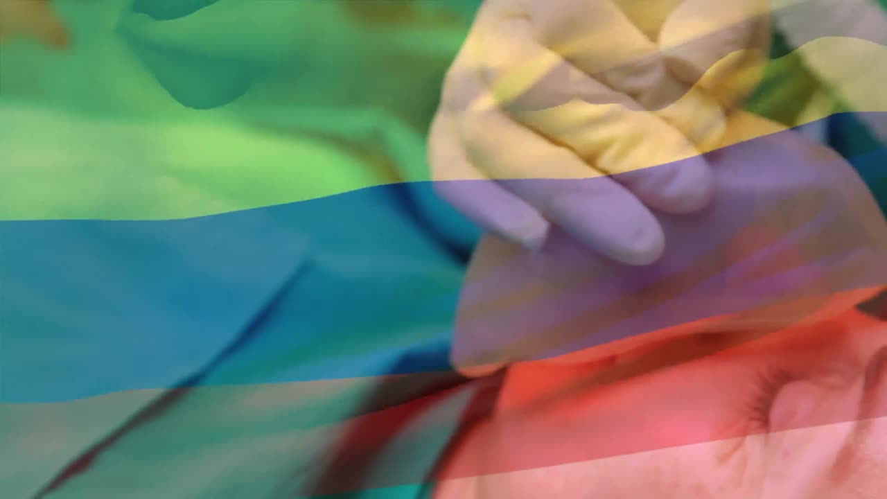 Animation of flag of camroon waving over surgeons in operating theatre