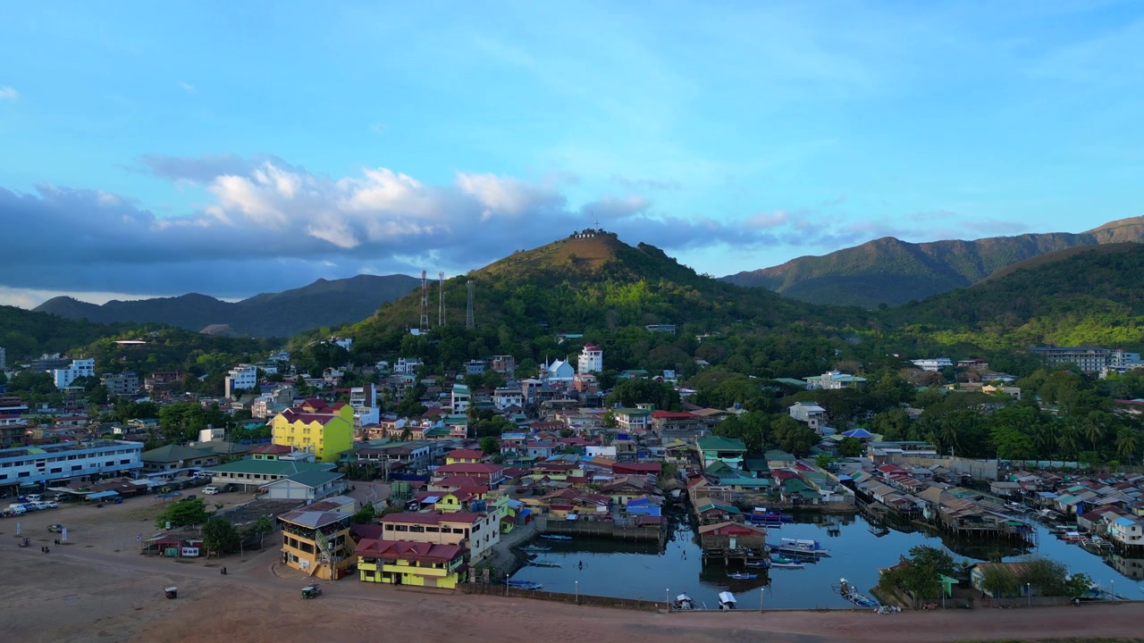 Coron, Palawan byudsigt fra oven, der viser byudvikling ved siden af en bugt og omgivet af bjerge. Betagende luftfoto droneoptagelse panorama fra oven.