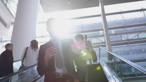 Businessman-using-mobile-phone-on-escalator-in-a-modern-office-4k