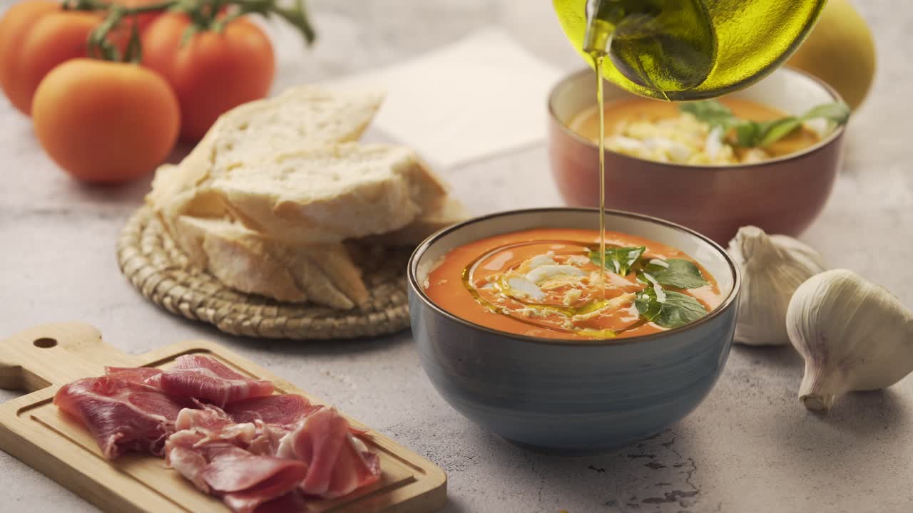 Adding olive oil to the salmorejo in the bowl