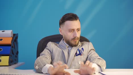 stressed and thoughtful overwhelmed businessman sitting at his desk and bored.
