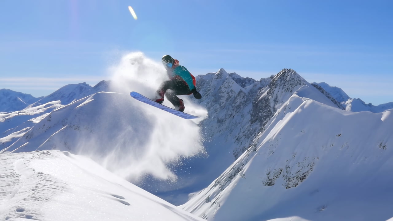 Slow Motion of Snowboarder Jumping on a Sunny Snowy Mountain