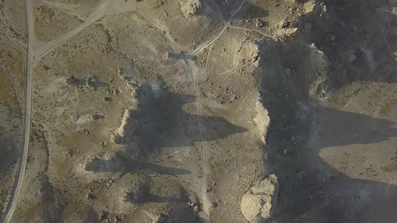 Birdseye view of a desert rock landscape filmed during sunset