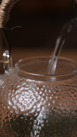 glass teapot with water pouring