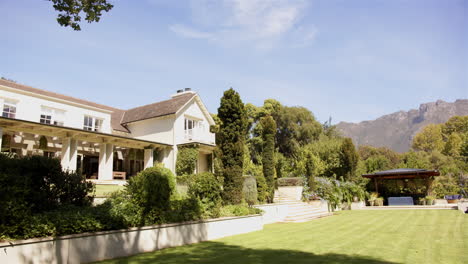 beautiful house with lush garden and mountain view on sunny day