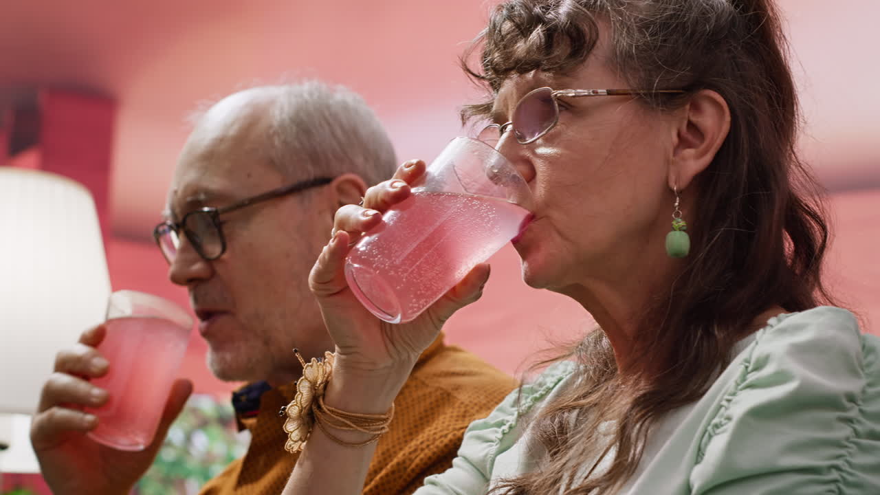 Senior man and woman serving their effervescent supplements with glass of water
