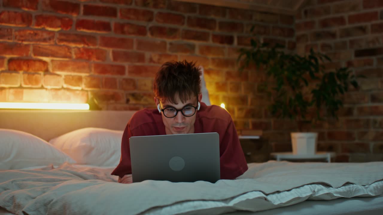 Man Working on Laptop in Bed at Night