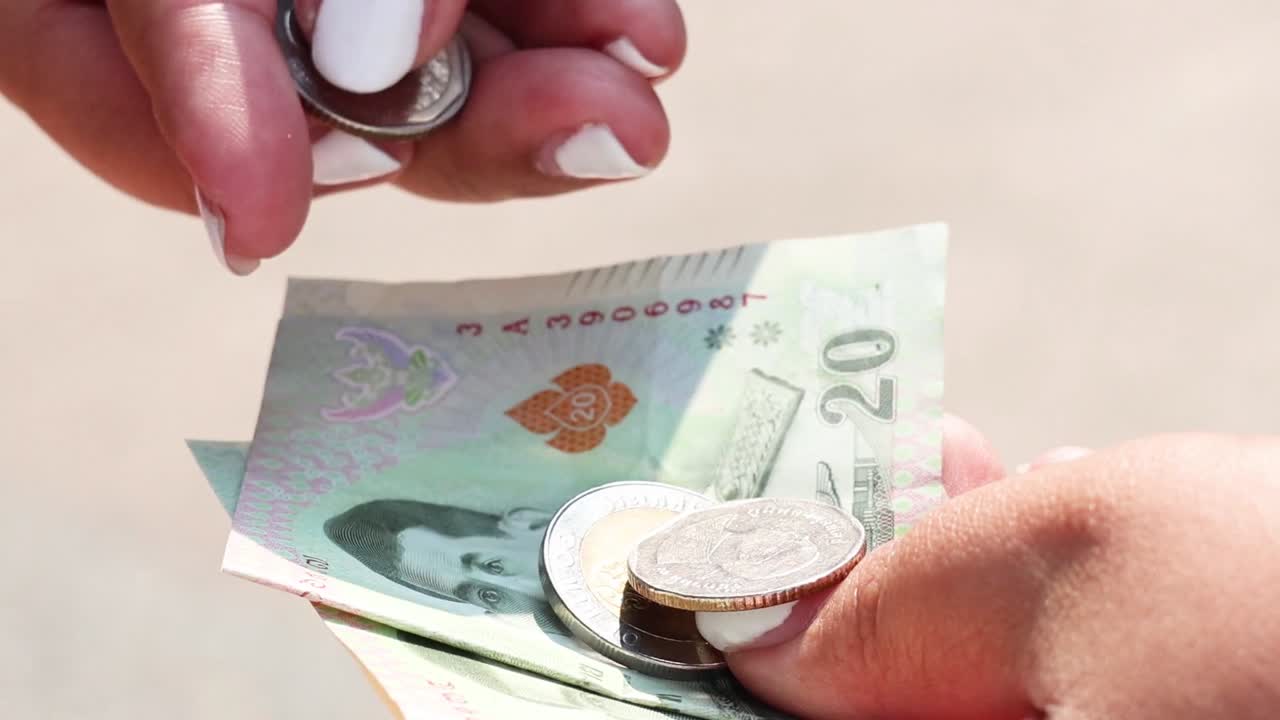Detailed view of hands handling banknotes and coins, focusing on currency exchange and counting.