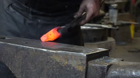 a blacksmith that is working hard to make an object with his hammer