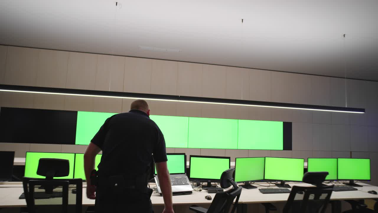 especialista en seguridad de sistemas que trabaja en el centro de control de sistemas. la habitación está llena de pantallas verdes, pantallas cromáticas y seguridad