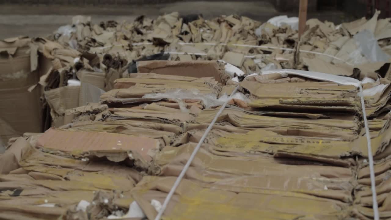 베일 머리 위의 넓은 크레인 샷의 판지 폐기물