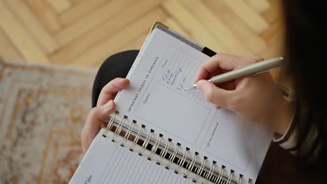 Woman-is-writing-down-a-schedule-in-her-agenda-paper-book