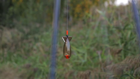 Slow-motion-footage-of-a-fishing-bait-suspended-on-a-fishing-line-on-a-windy-day