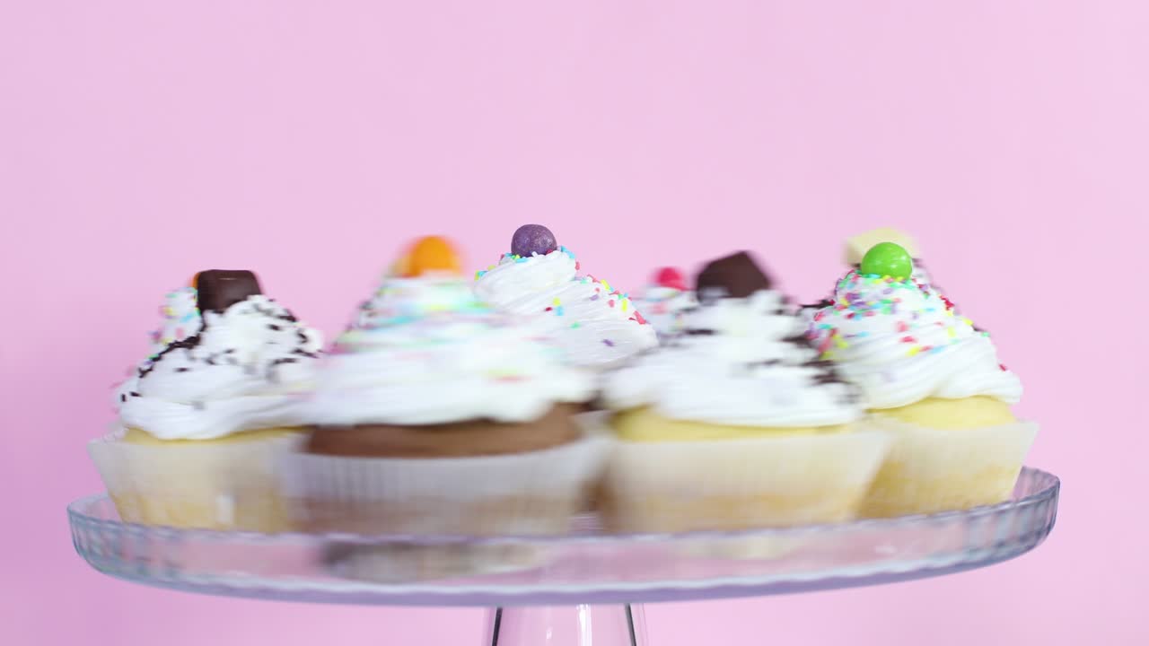 Cup cakes with white cream served on plate rotating