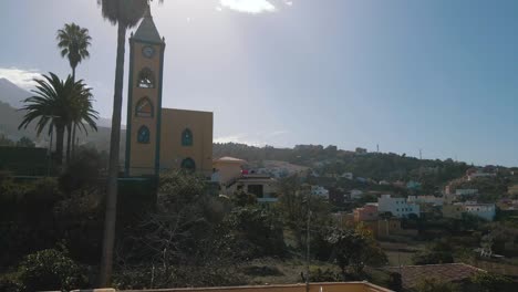 Aerial-Dolly-Shot-Going-Towards-Steeple-of-Church,-Church-Bell-and-Clock,-Spain