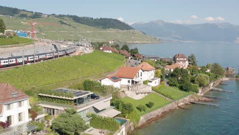 Drone-flying-over-beautiful-lakeside-properties-in-Switzerland