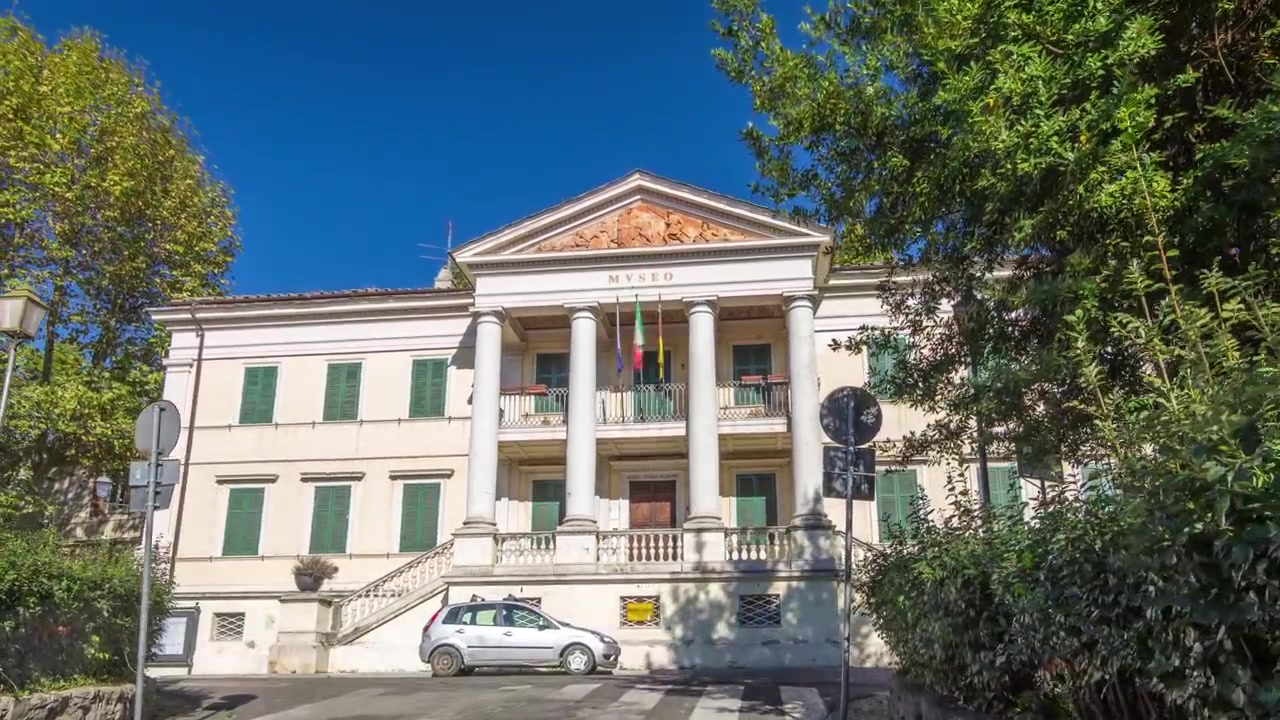 Timelapse Hyperlapse della Vista Frontale del Museo di Villa Ferrajoli nella pittoresca Albano Laziale, Italia. Museo Storico tra il Traffico su Affascinanti Strade Cittadine.