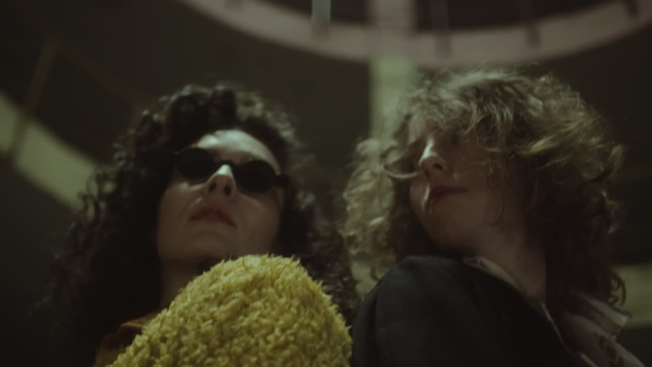 Women Posing Back to Back at Night