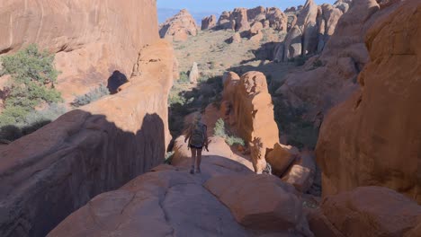 joven mujer rubia haciendo senderismo en el parque nacional arches, a cámara lenta a media velocidad