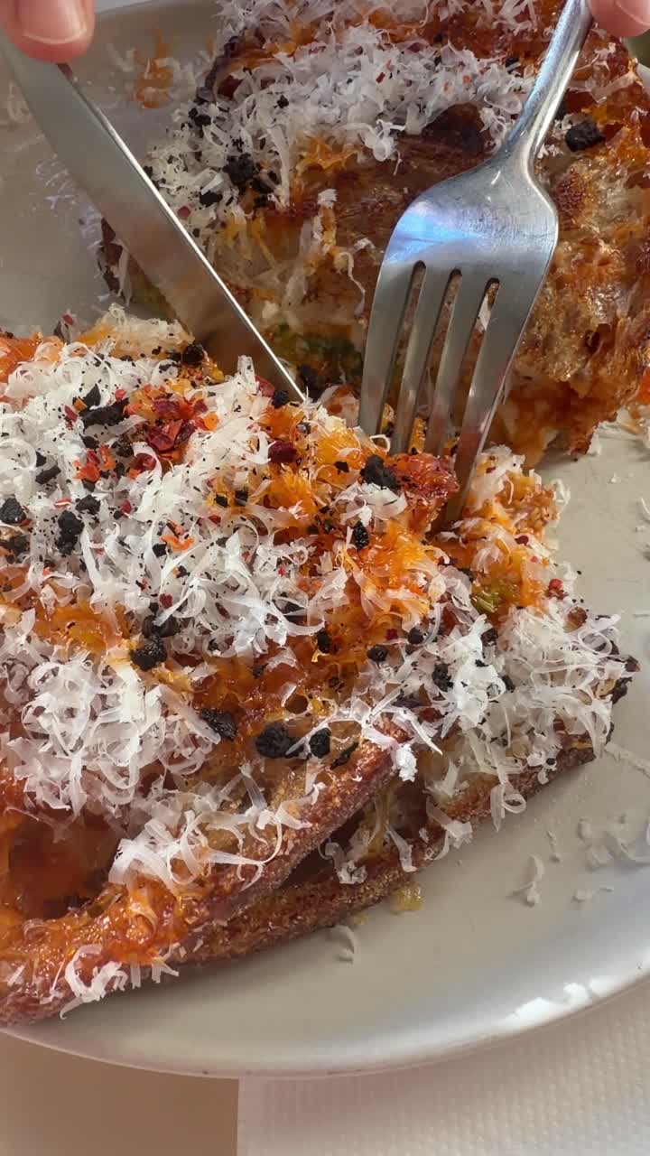 Delizioso toast al formaggio tagliato con forchetta e coltello.