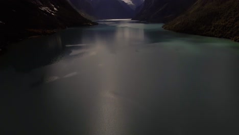 aerial of a lake surrouded by mountains in norway