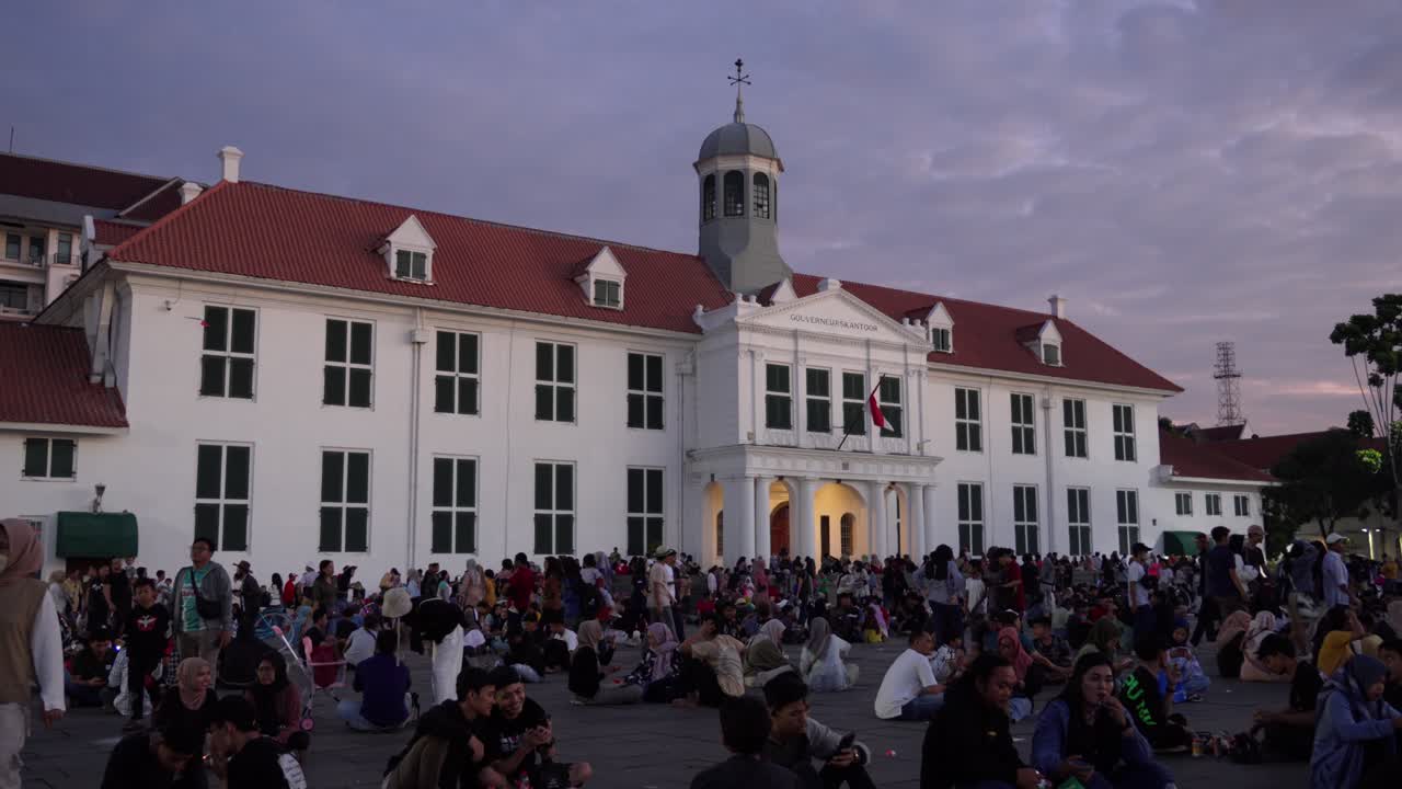 Crowd gathered in front of Jakarta History Museum in Fatahillah Square at dusk
