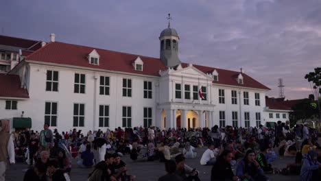 crowd gathered in front of jakarta history museum in fatahillah square at dusk