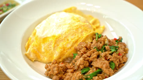 cerdo salteado y albahaca con tortilla cremosa sobre arroz - estilo de comida asiática