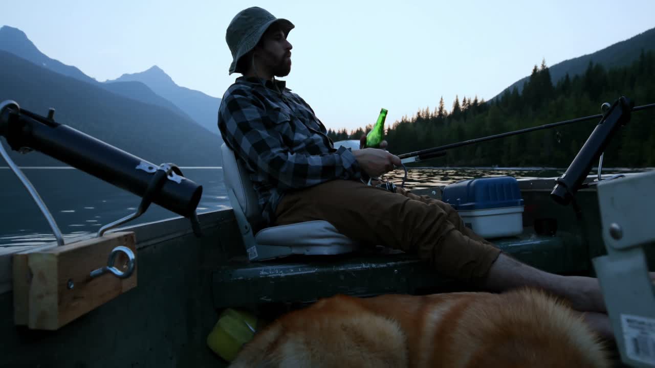 pescador tomando cerveza mientras pesca en el río 4k